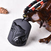 Black obsidian wolf pendant resting on a wooden display stand