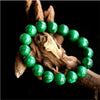 Green jade bead bracelet resting on driftwood