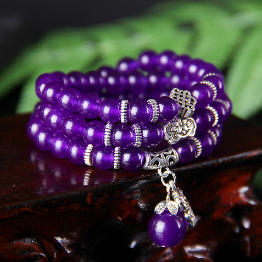 Triple wrap purple chalcedony bracelet with silver Pixiu charm on wood