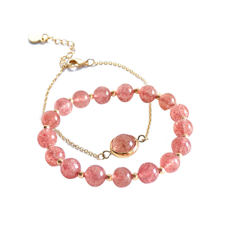 Pink strawberry quartz beaded bracelet with gold chain on white background
