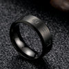 Close up of a black stainless steel ring with engraved Tibetan script