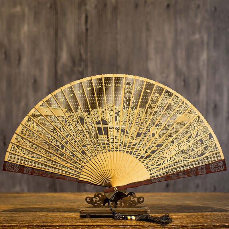 Close up of the light colored sandalwood fan showing detailed hollow carving work