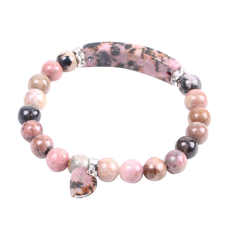 Pink rhodochrosite beaded bracelet with a heart pendant on a white background