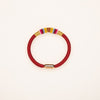 Close-up of a red braided bracelet with colorful knot details and a gold magnetic clasp on a white background