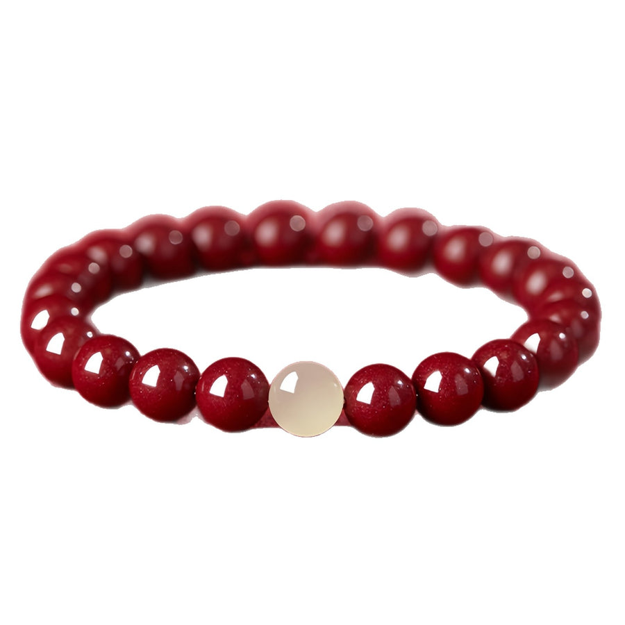 Single loop bracelet with round red cinnabar beads and one pale accent bead