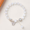 White cat's eye beaded bracelet with silver butterfly charm and grey accents