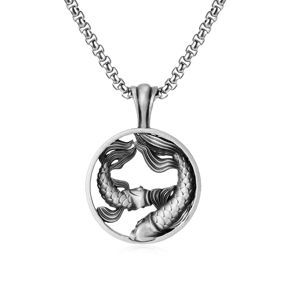 Close up view of a round silver pendant showing two fish swimming in a circle