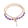 A double wrap bracelet featuring white pearls and purple amethyst beads with gold-tone accents on a white background.