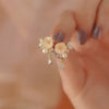 Gold-tone camellia flower stud earrings with faux pearl accents