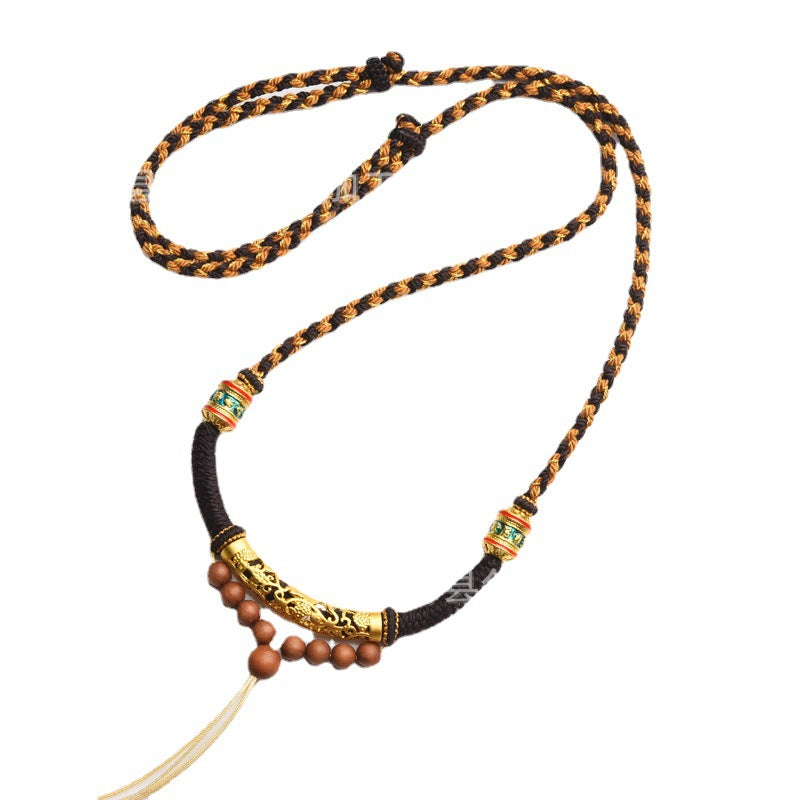 Close up of a brown and gold hand-braided necklace with alloy beads and tassel ends.