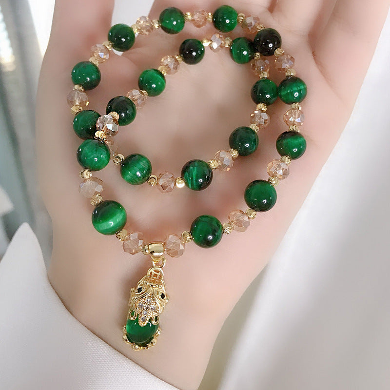 Green double wrap bracelet with Pixiu charm and crystal beads held in hand