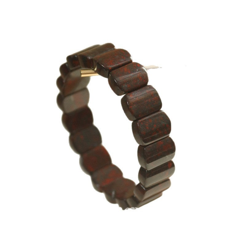 A close-up of a dark red natural stone bracelet with rectangular beads on a white background