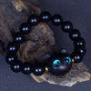 Close up of an ebony wood bead bracelet with a black cat charm