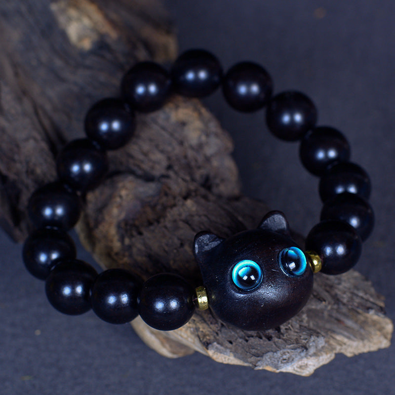 Close up of an ebony wood bead bracelet with a black cat charm