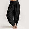 Model wearing black solid color loose fit harem pants with a folded elastic waistband