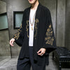 Man wearing a black open-front kimono jacket with embroidered designs