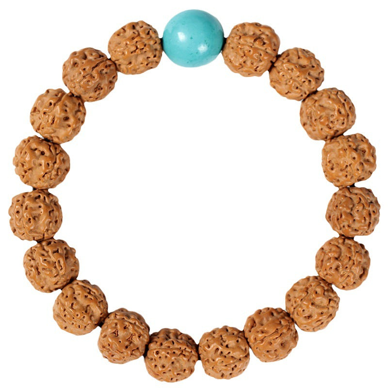 Close-up of a brown textured Bodhi seed bracelet with a yellow amber accent bead on a gray background