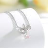 Sterling silver lotus flower necklace with a dangling pink rose quartz stone on a white background