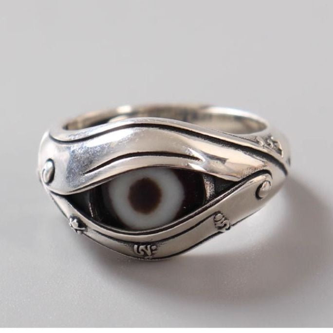 Close-up of a silver-tone adjustable ring featuring a black and white imitation Dzi eye stone