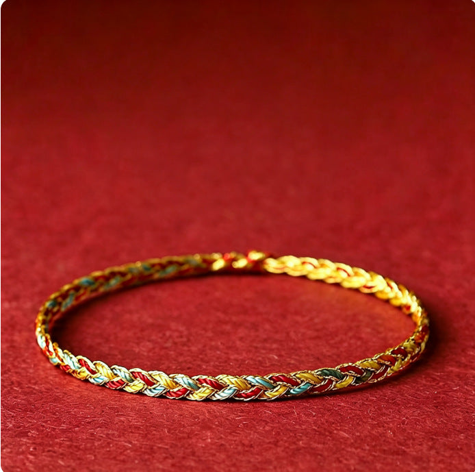 Close up of a multicolored braided string bracelet on a red background