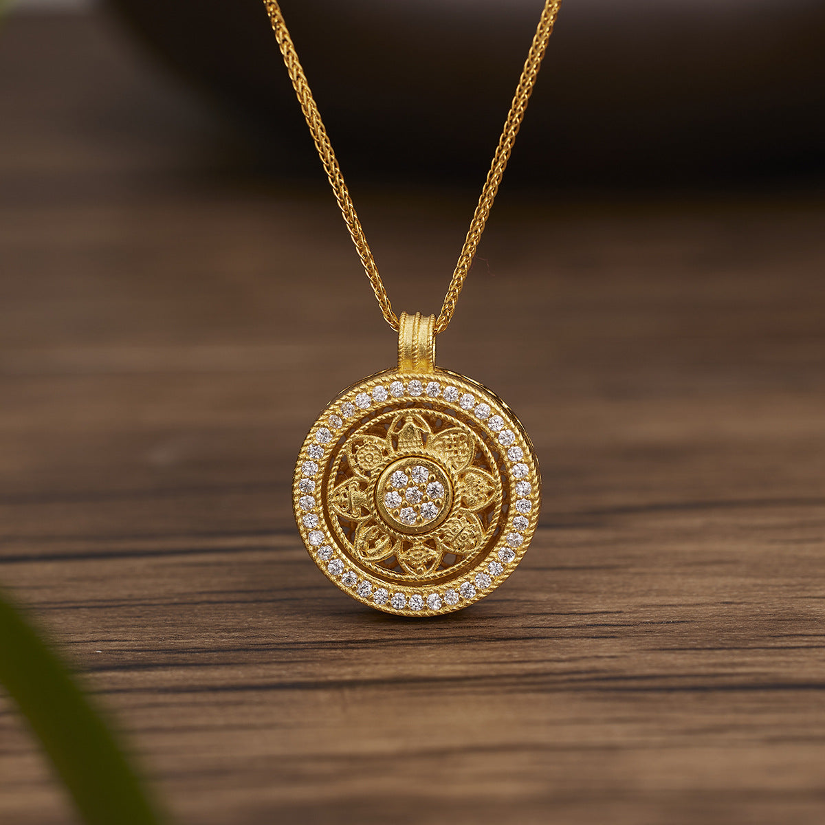 Gold-tone 925 silver necklace with a round rotating pendant featuring eight treasures and stone accents