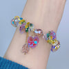 Close up of a crystal beaded bracelet with a pink heart charm on a wrist