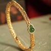Gold tone copper bangle with green jade gourd charm and cloud patterns