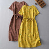 Yellow and brown polka dot linen dresses with tie belts laid flat