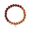 A circular bracelet made of red cinnabar and light brown peach wood beads on a white background