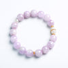 Lavender Kunzite beaded bracelet with white jade gourd charm on a book
