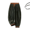 Dark green corduroy women's harem pants with brown trim and drawstring waist