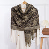 Woman wearing a burgundy paisley shawl with tassels outdoors in autumn light