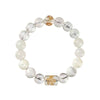 Close up of a beaded bracelet with clear and yellow crystals and a gold charm
