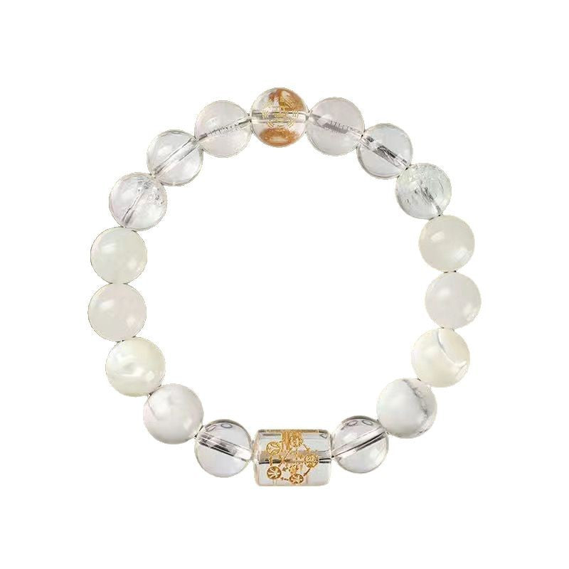 Close up of a beaded bracelet with clear and yellow crystals and a gold charm