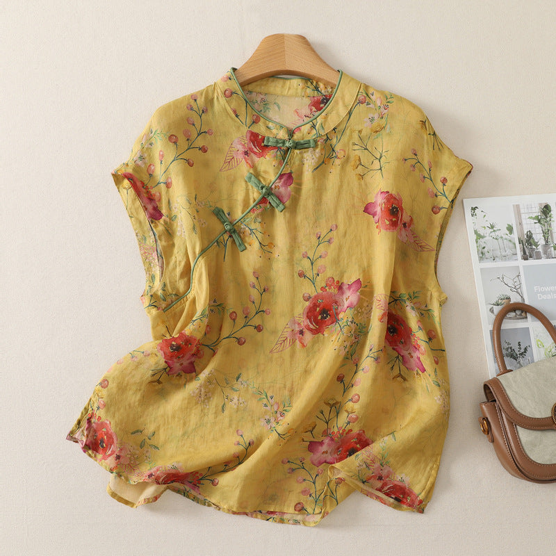 Yellow sleeveless tank top with red floral pattern and green frog buttons on a hanger