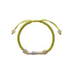 Close up of a woven bracelet with a silver bamboo charm on a wrist