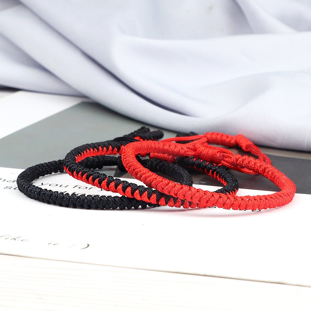 Stack of three handwoven red and black string bracelets