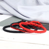 Stack of three handwoven red and black string bracelets