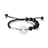 A close-up view of the black obsidian and white chalcedony peace buckle bracelet on a wrist.