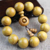 Close-up of a light-colored wooden bead bracelet with a guru bead and tassel.