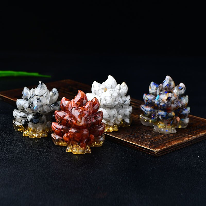 Small nine tailed fox figurine made of colorful crushed crystals on a wooden surface