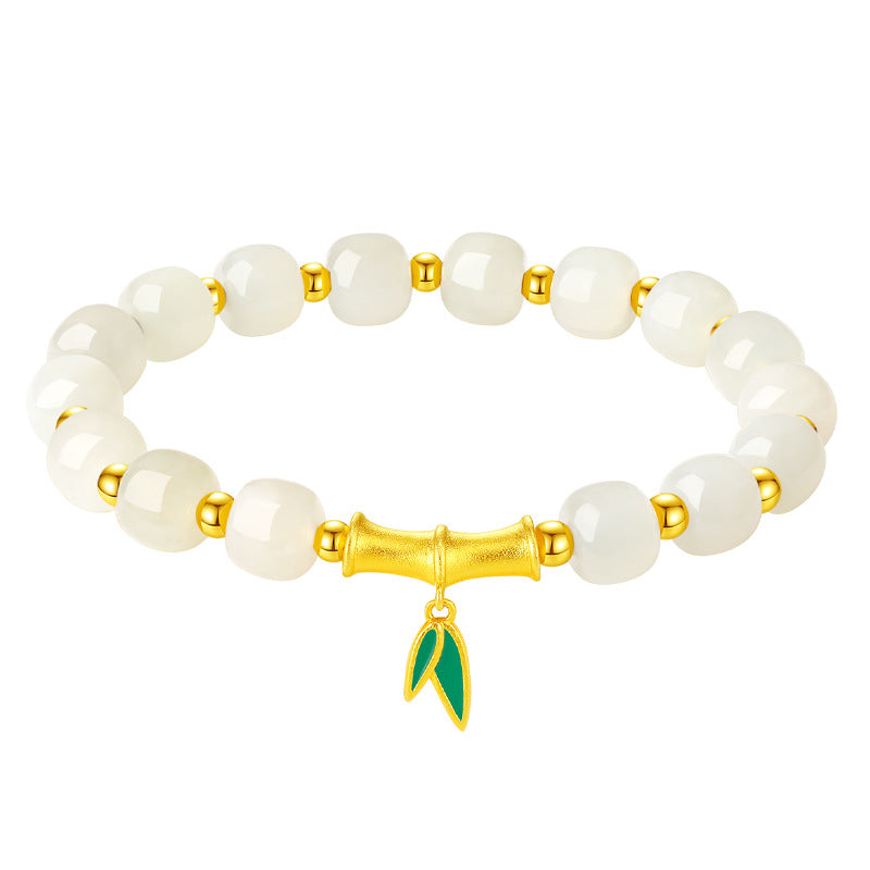 White jade bead bracelet with gold-tone bamboo charm and green leaf pendant on wrist