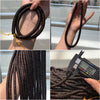 Strands of dark brown coconut shell beads held in hand