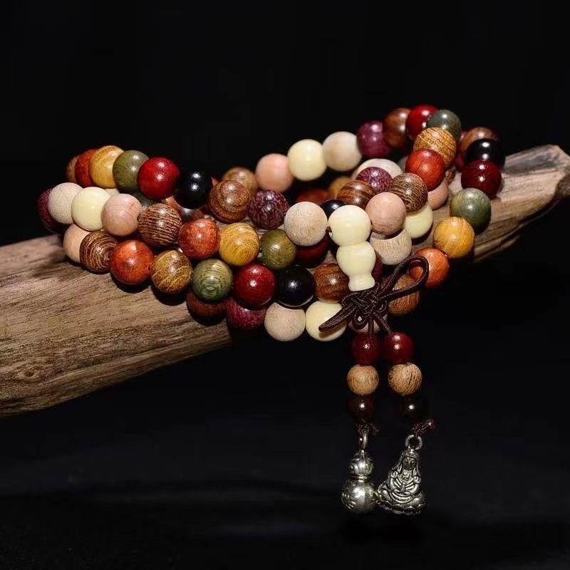 Multi-colored 108 bead wood mala bracelet wrapped on driftwood