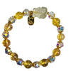 Close-up of a beaded bracelet with yellow citrine and clear quartz beads featuring a carved fox charm