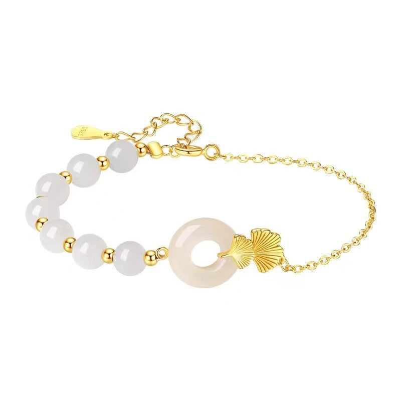 Gold-tone chain bracelet with white jade beads and a circular pendant