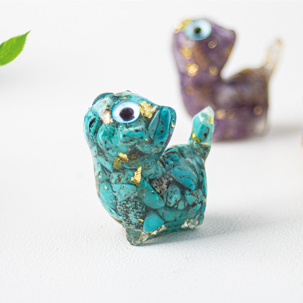 Close up of a blue green resin cat figurine with crystal chips