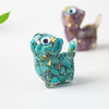 Close up of a blue green resin cat figurine with crystal chips