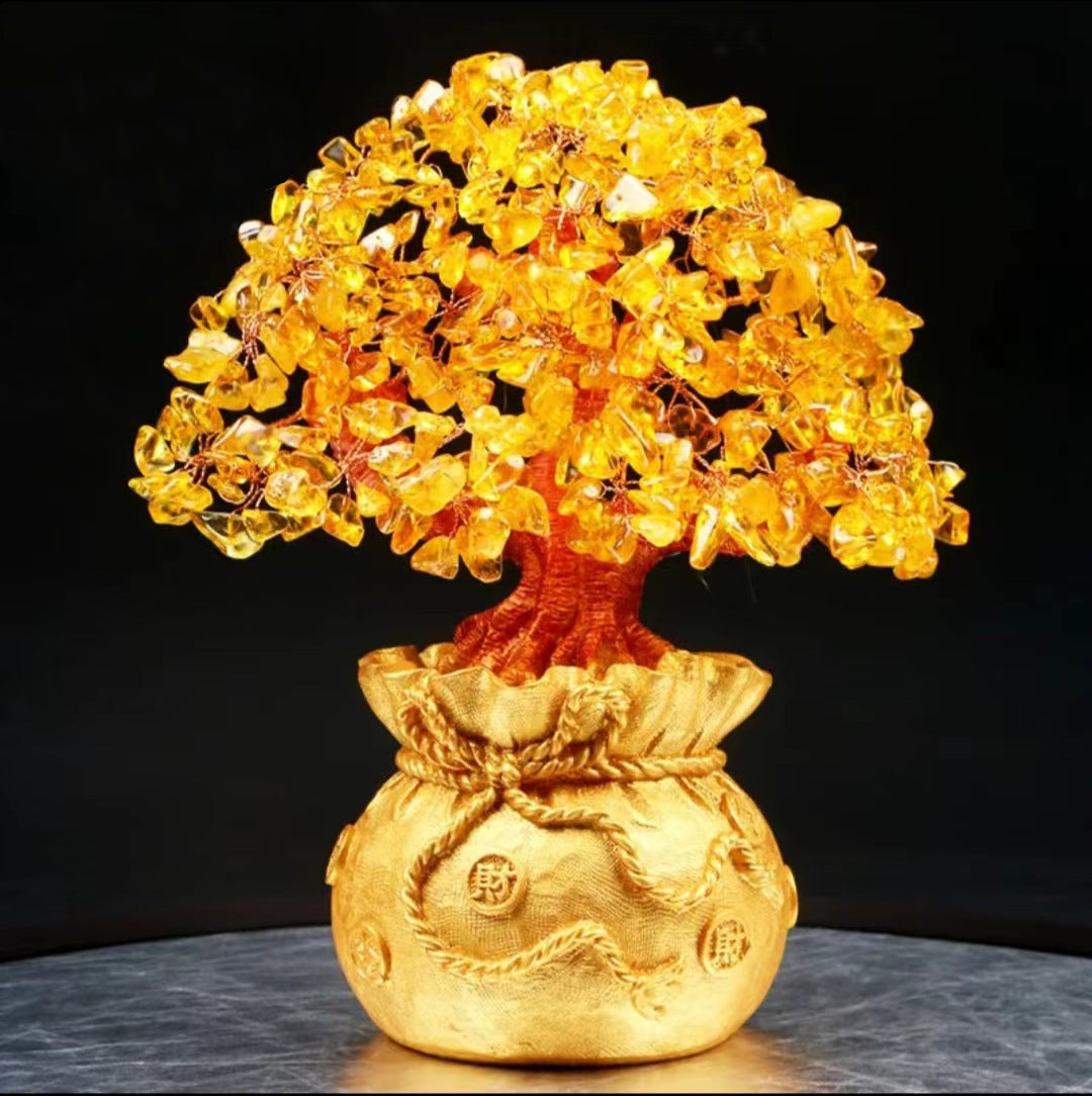 Golden money bag planter with yellow gemstone leaves on a dark surface