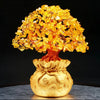 Golden money bag planter with yellow gemstone leaves on a dark surface